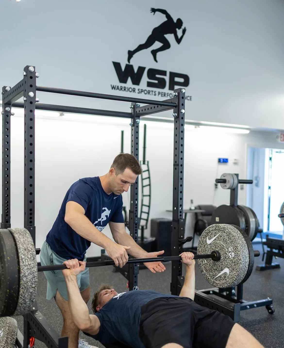 Coach assisting a barbell squat in color