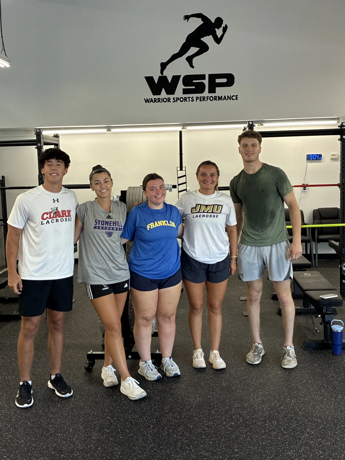 Athletes together beneath the WSP wall logo